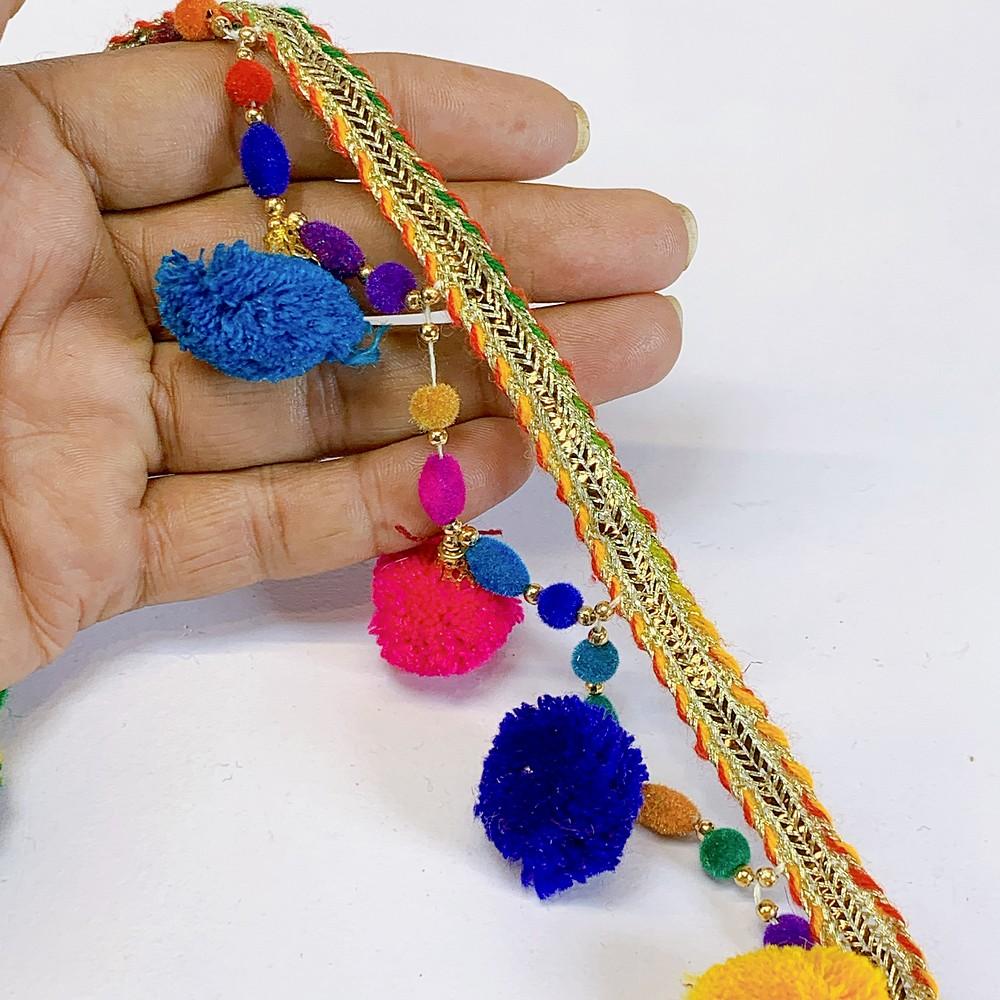 45mm PomPom Multicolour Beaded Fringe, shown on white cotton