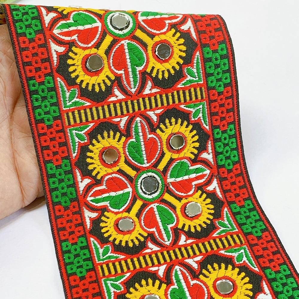 100mm Kutchi Design Jacquard Lace With Mirror Work, shown on white cotton