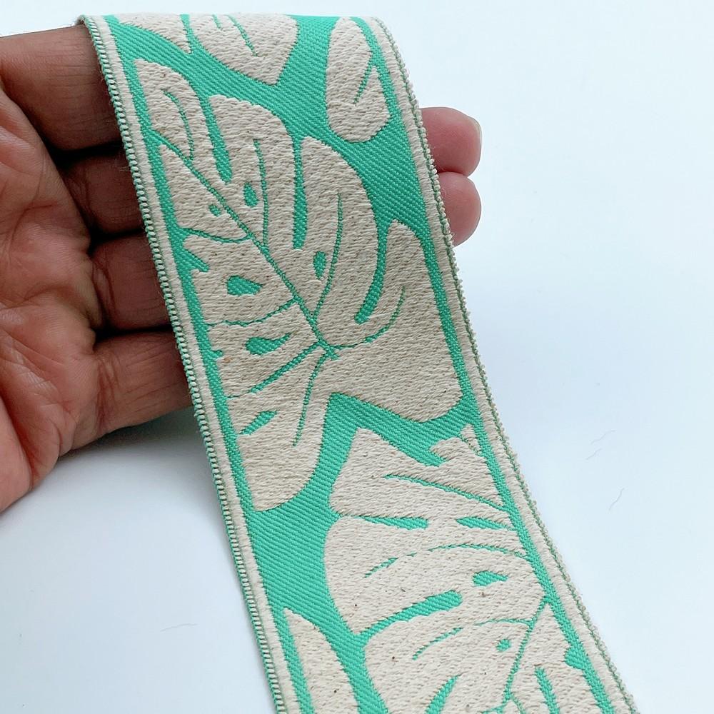 58mm Wide Tropical Monstera Leaf Pattern Lace Border for Sewing, Garments, DIY Crafts & Home Decor, shown on white cotton