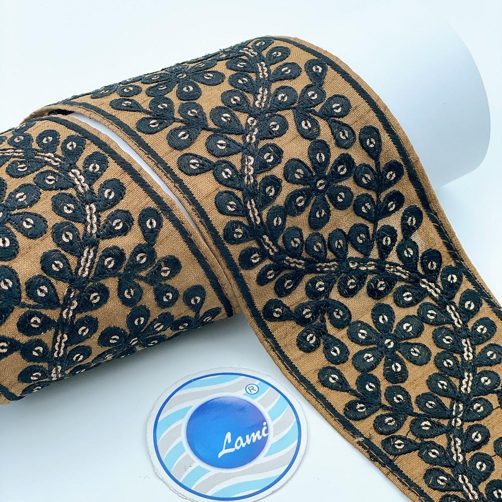 70mm Elegant Black & Gold Embroidered Lace, shown on white cotton
